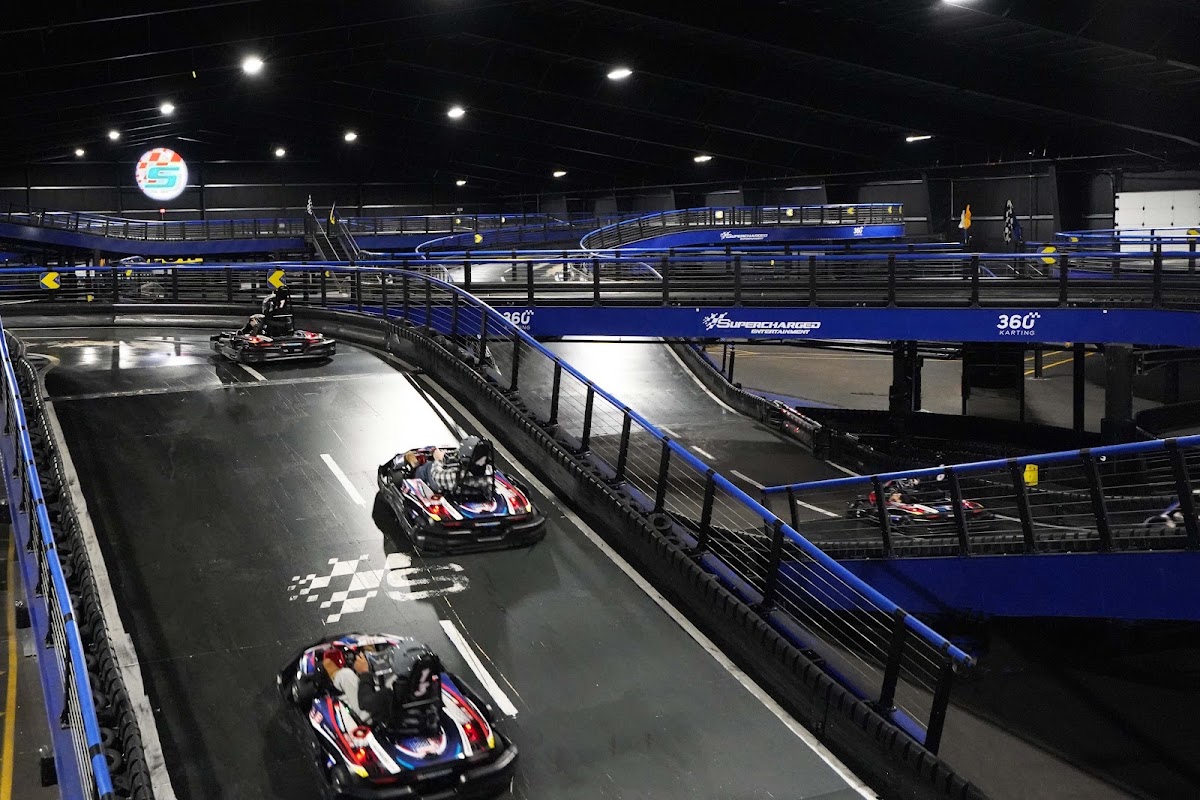 Electric go-karts racing on a multi-level indoor track near Boston
